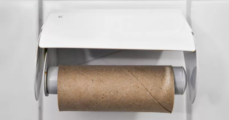En tom toapappersrulle i en hållare.