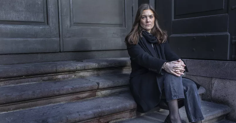 Klara Petersson sitter på en trappa utomhus.
