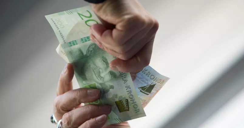 Händer som räcker pengar mellan varandra.