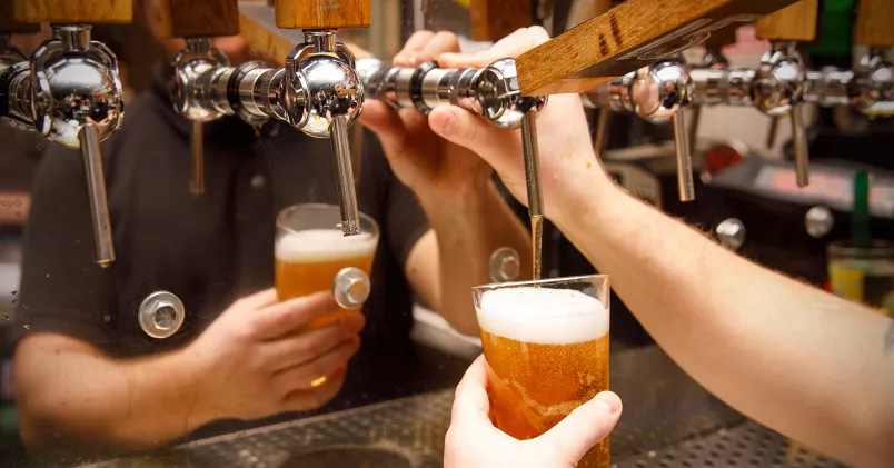 Bryggeribranschen pressas av prisökningar. Man häller upp öl från kran.