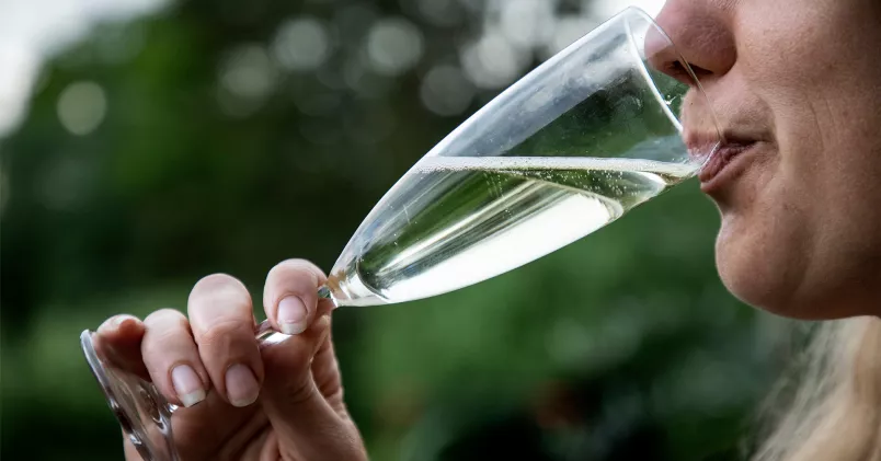 Vill du dra ned på alkoholen? Här är expertens tips. Kvinna dricker ur champagneglas