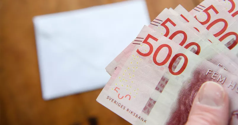 Vissa kommer få fortsatt inbetalning till ITP fram till 66 år, efter årsskiftet. Person håller i femhundralappar