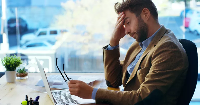 trött man lutar huvudet i handen