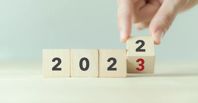 hand vänder kloss från 2022 till 2023.