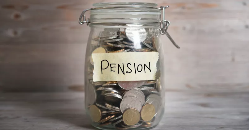 Löneväxling. Glasburk med mynt och etikett med texten "pension".