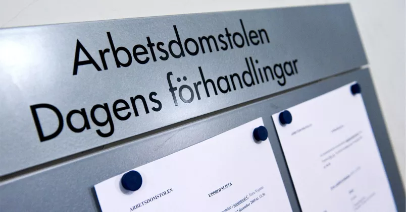 Skylt i grå metall med fastsatta pappersark som visar dagens förhandlingar i Arbetsdomstolen. 
