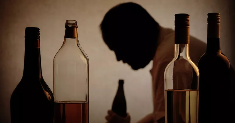 man som sitter lutad över vinflaska man som sitter lutad över vinflaska