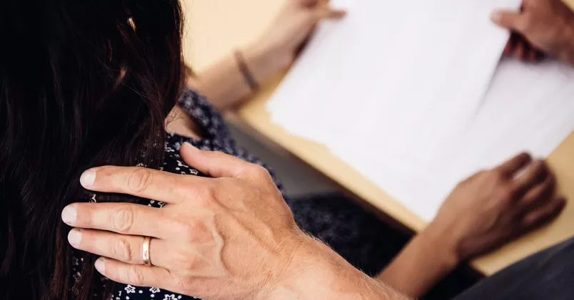 Unionen stämmer arbetsgivaren för sexuella trakasserier mot en kvinna. Man lägger hand på en axel.