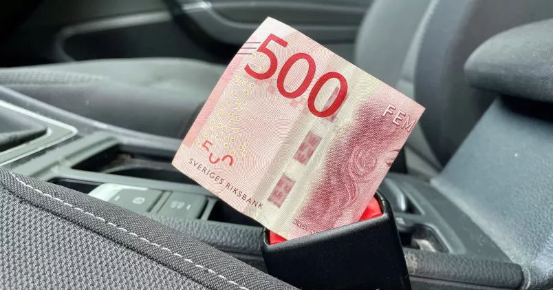 En femhundralapp nedstucken i bilbälteslåset på en personbil. 