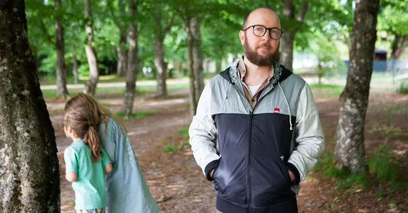 Christian Lillihöök utomhus med sina två barn i en park.