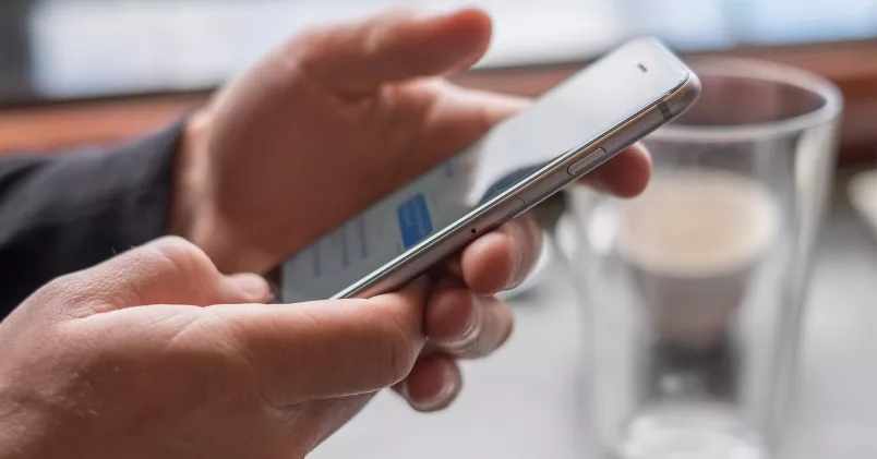 Man tittar på sin smartphone och läser ett sms