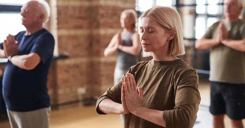 En grupp mogna personer i en yogastudio.