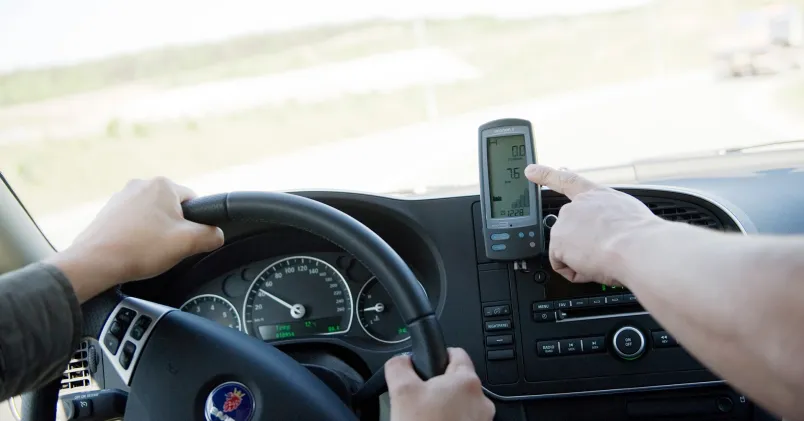 trafiklärare hand pekar mot en maskin som mäter eco-driving
