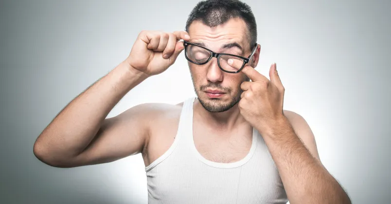Man som kliar sig i ögat