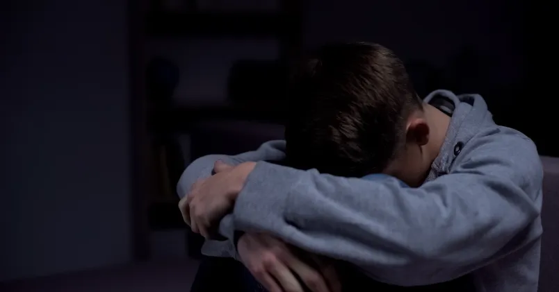 Man som sitter i mörkret