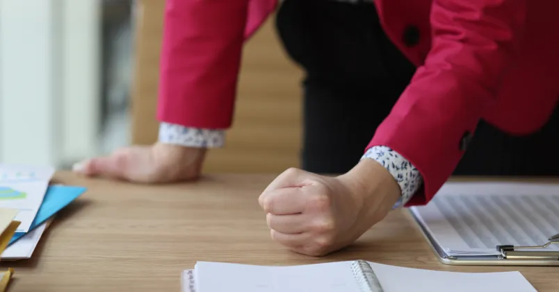 En kvinna slår näven i bordet