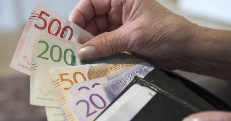 Hand med svenska sedlar