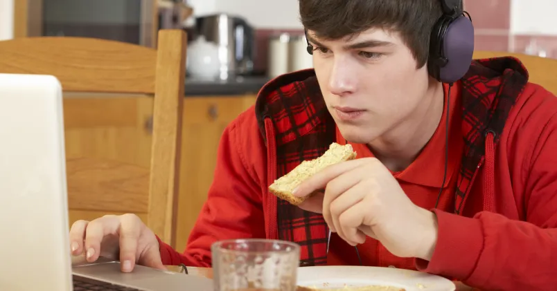 Kille sitter framför en dator