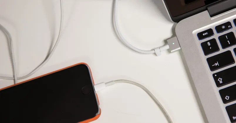 En laptop och en mobiltelefon ligger på laddning.