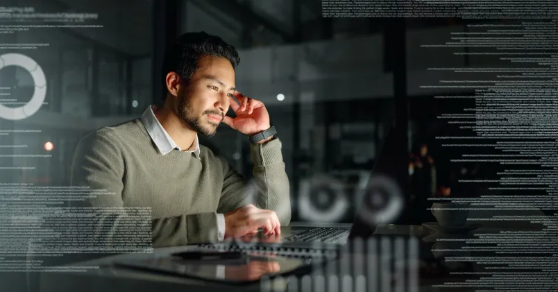 En man sitter framför sin dator. I bakgrunden syns långa rader av genomskinlig text.