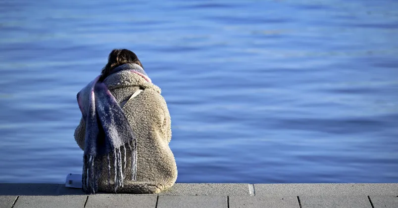 En kvinna sitter på en brygga