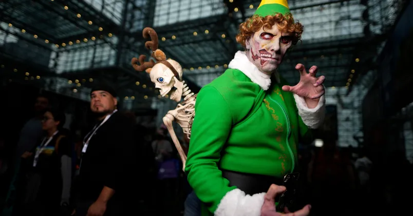 En man har klätt ut sig till karaktären Elf i knallgröna kläder.