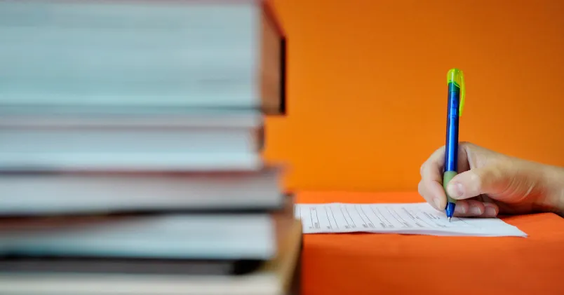 En hand som håller i en penna