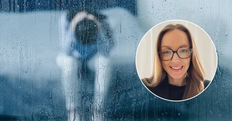 Kvinna sitter lutad över en säng