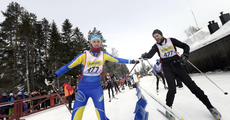 Stafett i Vasaloppet, två åkare växlar över till varandra.