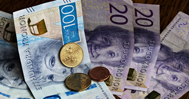 Svenska sedlar och mynt i kronor, illustration för artikel om snittlöner och högst betalda yrken i Sverige.