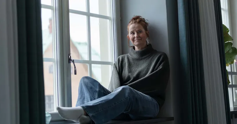 Caroline Nordström sitter i en fönsterkarm