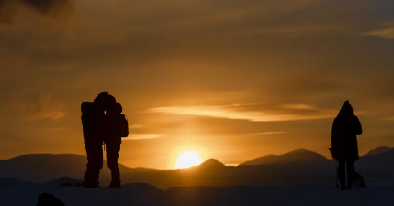 Ett par håller om varandra i solnedgången