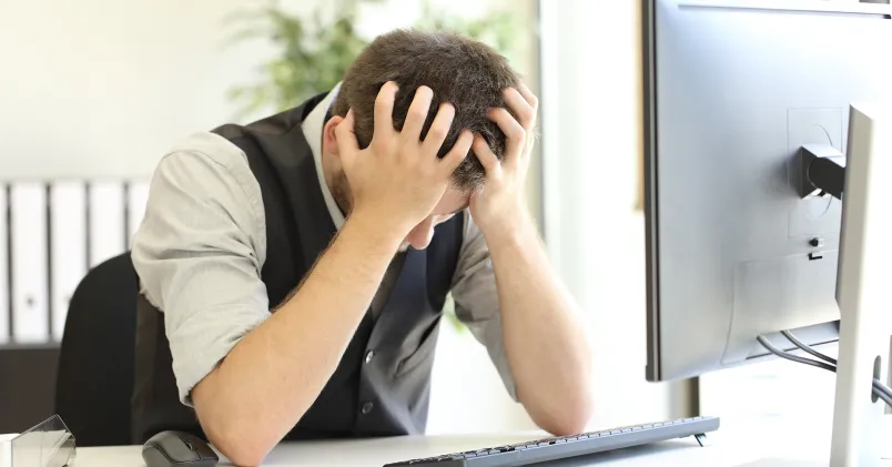 Tjänsteman sliter sitt hår framför datorn