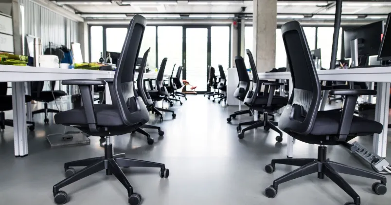 Kontorsstolar i ett ljust kontor som används för att belysa fråga om det är tillåtet att ta arbetsplatsens saker hem.