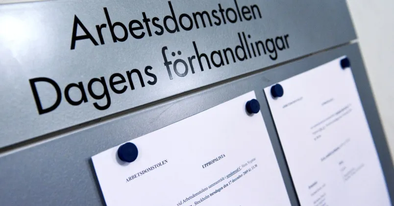 En skylt med texten "Arbetsdomstolen Dagens Förhandlingar" uppsatt på en vägg