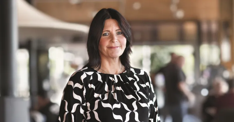 Erica Sundberg, operativ chef på TRR, står i en kontorsmiljö. Bilden kopplar till TRR:s stöd för chefer som söker nytt jobb.