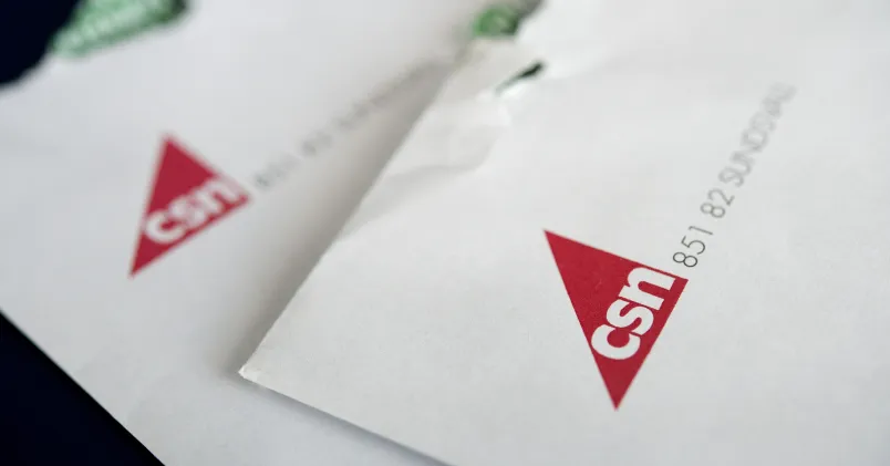 Närbild på två kuvert eller papper med CSN:s röda logotyp, som illustrerar studielån och återbetalning.
