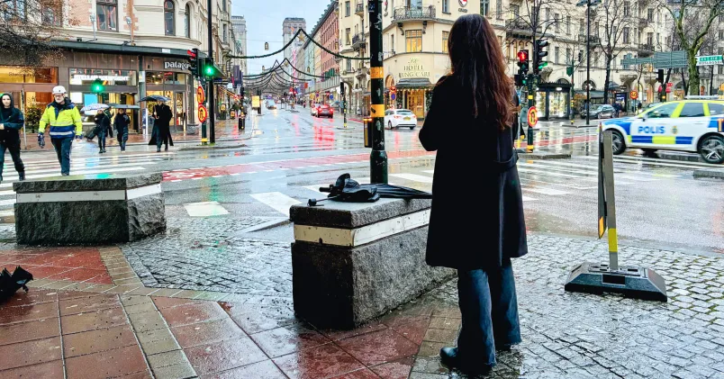 Gatumiljö i centrala Stockholm med en person sedd bakifrån och polisbil i bakgrunden. Bilden illustrerar en arbetsrättslig tvist som lett till ny stämning.