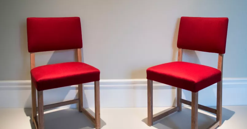 Två röda Bonde-stolar designade av Carl Malmsten.