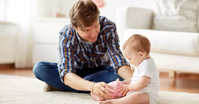 Pappa och bebis leker på golvet.