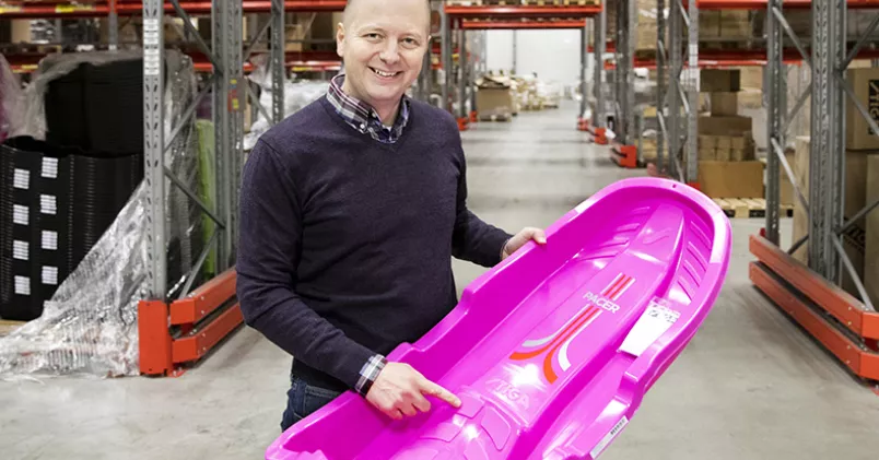 Jonas LIndfors, håller upp en rosa pulka från Stiga.