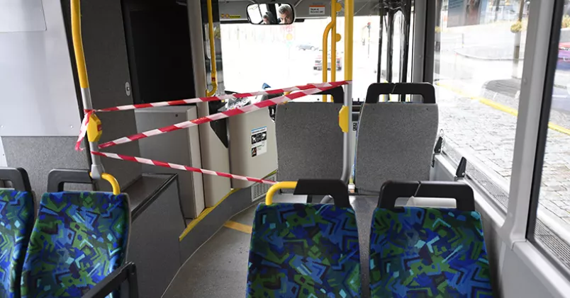 För att skydda bussförare från corona stängde företag inom kollektivtrafiken framdörrarna för påstigning, innan man införde skyddsglas. Buss med avspärrning framme vid föraren.