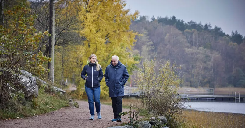 Liselotte Ahnfelt och Mikael Kjellström promenerar i höstlandskap.