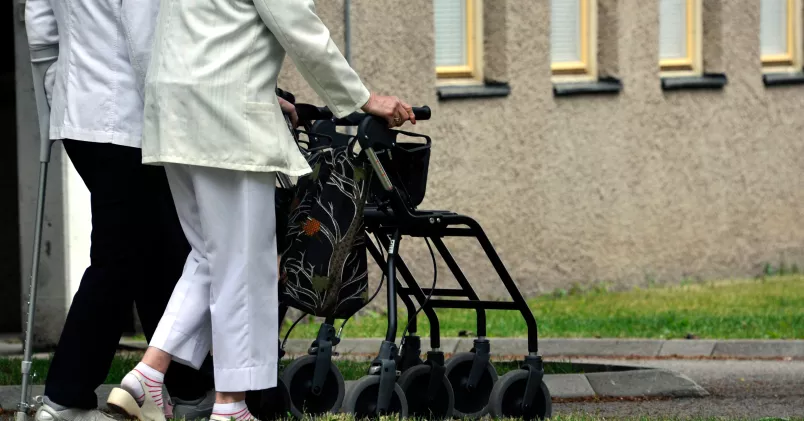 Två personer promenerar med varsin rollator.