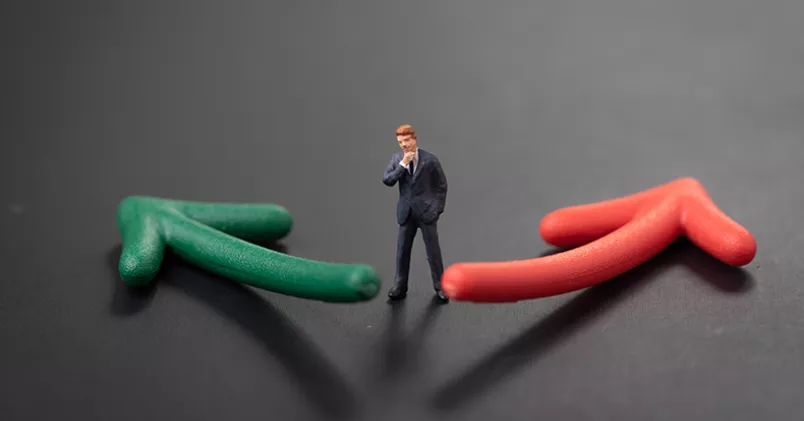 Man står och funderar mellan en grön och en röd pil som leder åt olika håll.