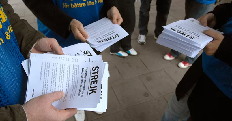 Personer delar ut informationsblad om strejk.