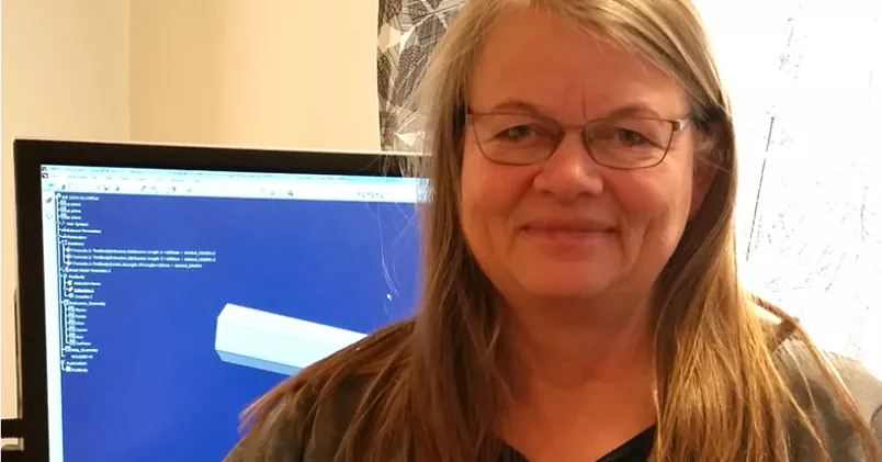 Susanne Karlsson framför sin skärm och arbetsplats.