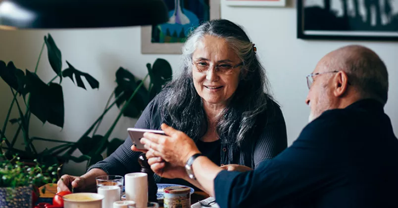 Man och kvinna i pensionsålder sitter vid matbord.