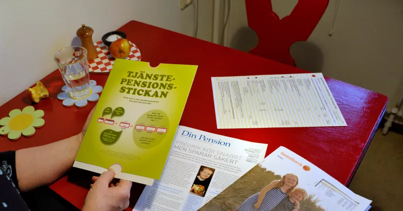 Kvinna håller i informationsbroschyr om pension.