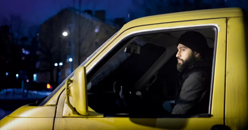 Mobin Ansari i en gul bil i rollen som statist.